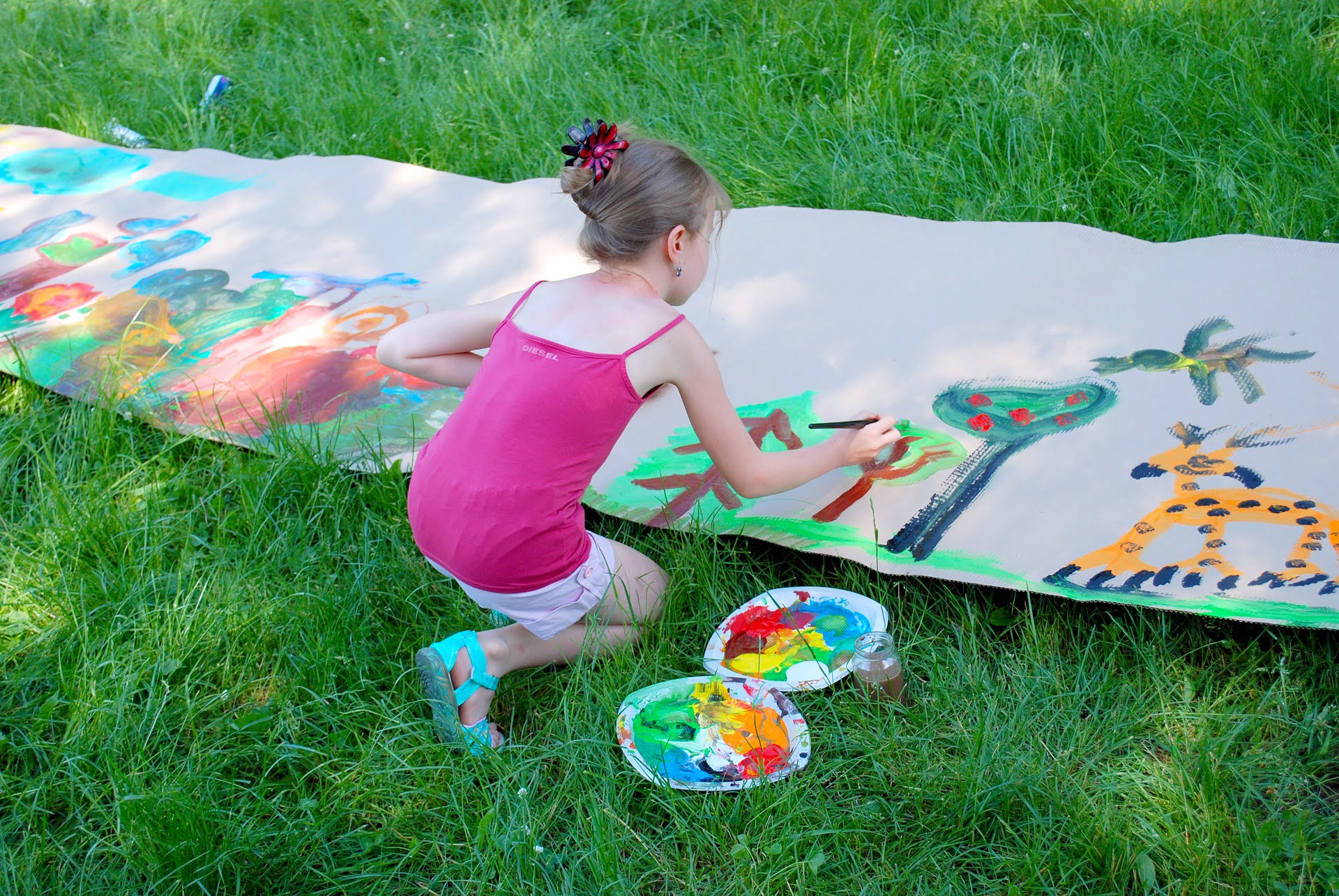 Dziewczynka malująca farbami na dużym papierze